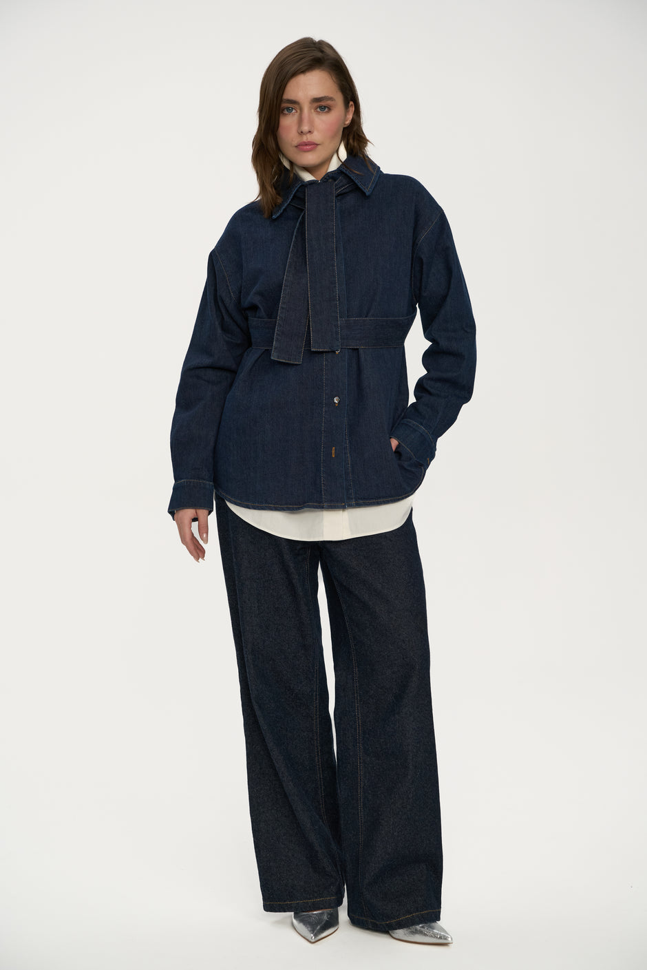 Woman wearing a dark blue denim jacket on a white background