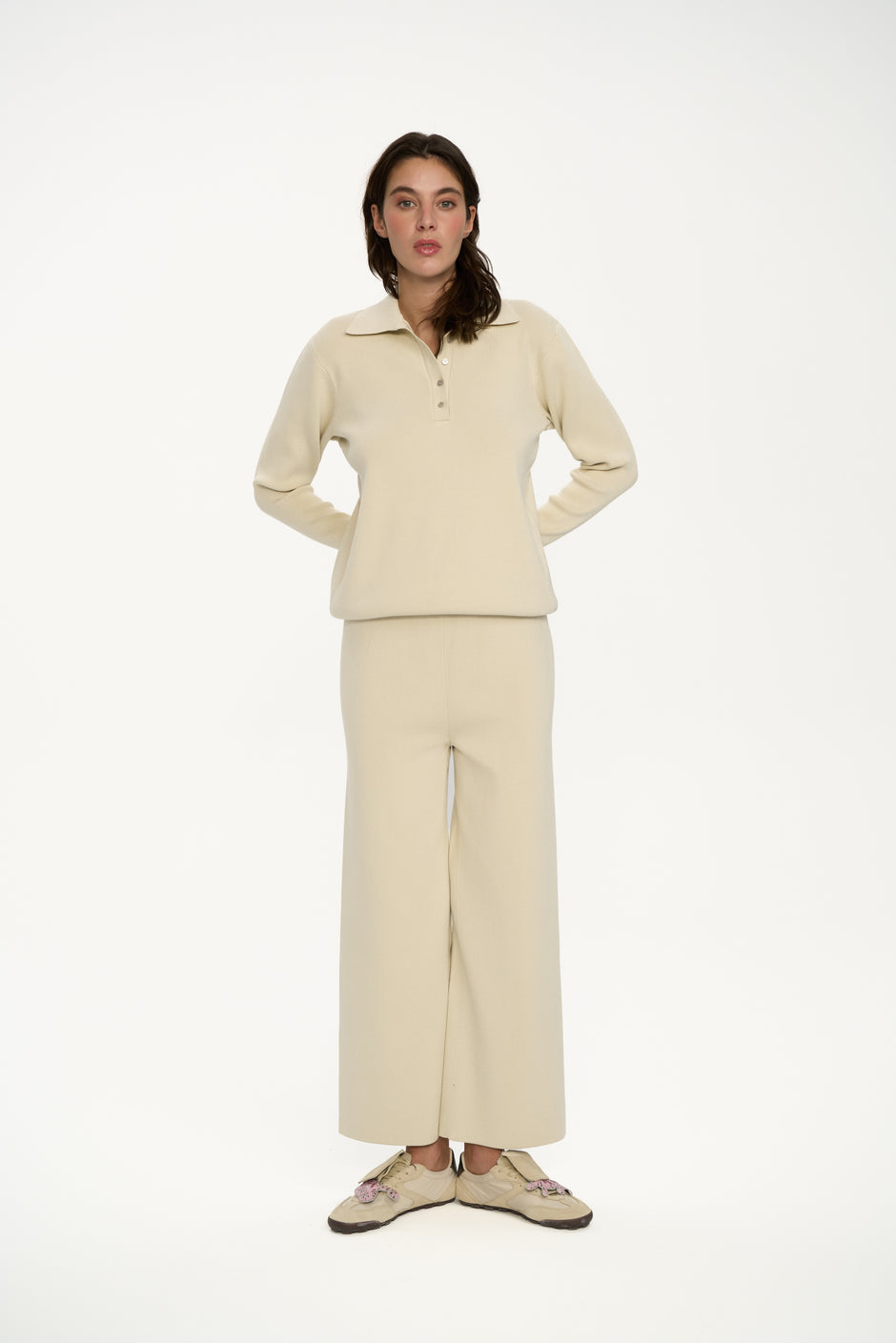 Woman wearing a beige outfit on a white background fun pose