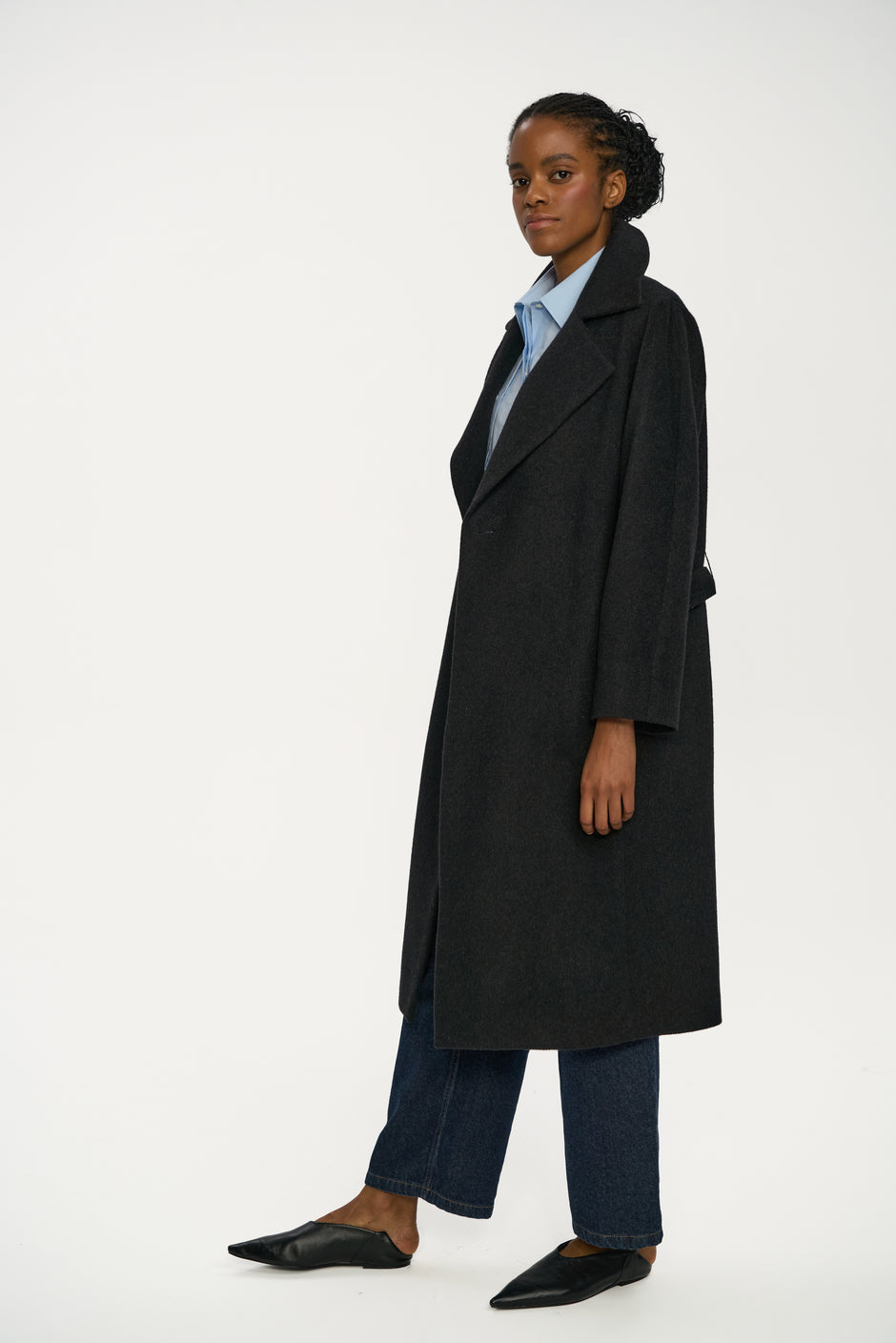 Person wearing a black coat on a white background