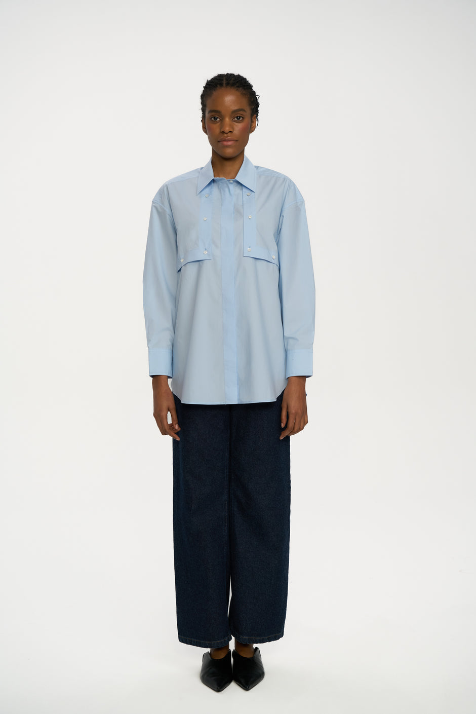 Light blue cotton breastfeeding-friendly shirt with flap detail styled with dark indigo wide-leg jeans and black pointed shoes, full length front view – Inner Tiger