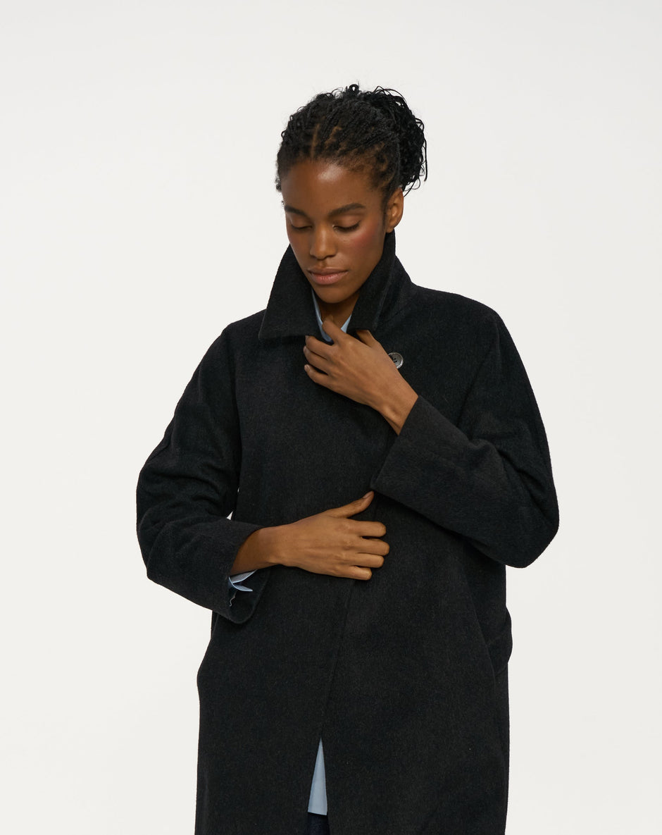 Close-up of dark charcoal cashmere wrap coat showing wide lapels and clean front line over blue shirt – Inner Tiger