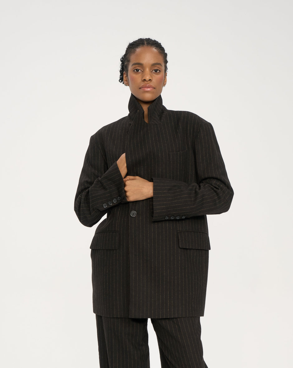 Oversized chocolate pinstripe suit jacket in soft wool-blend flannel, peak lapels and flap pockets, on model standing – Inner Tiger