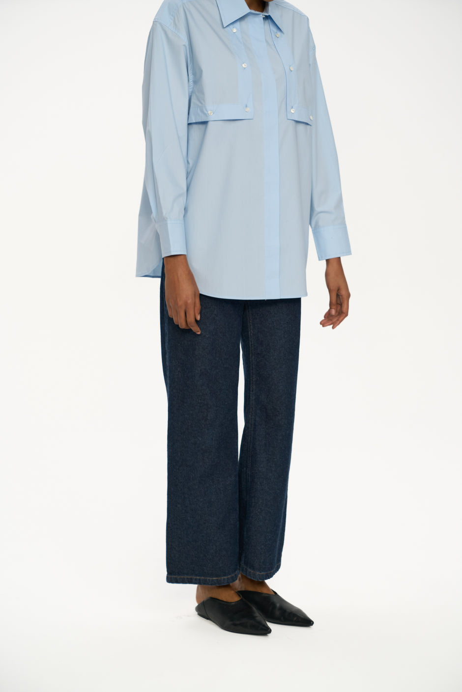 Person wearing a light blue shirt and dark blue pants on a white background Inner Tiger