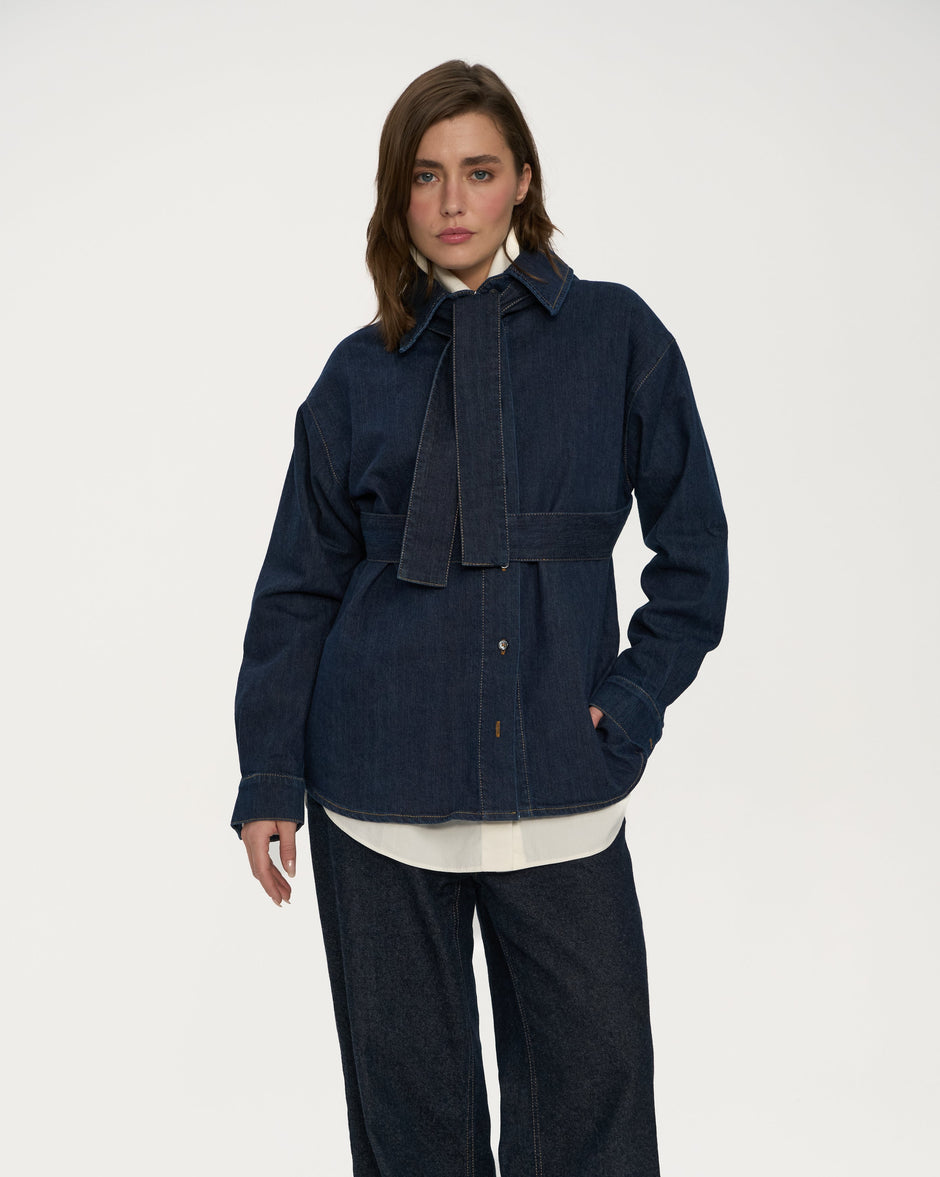 Person wearing a navy blue outfit with wide-leg pants on a white background