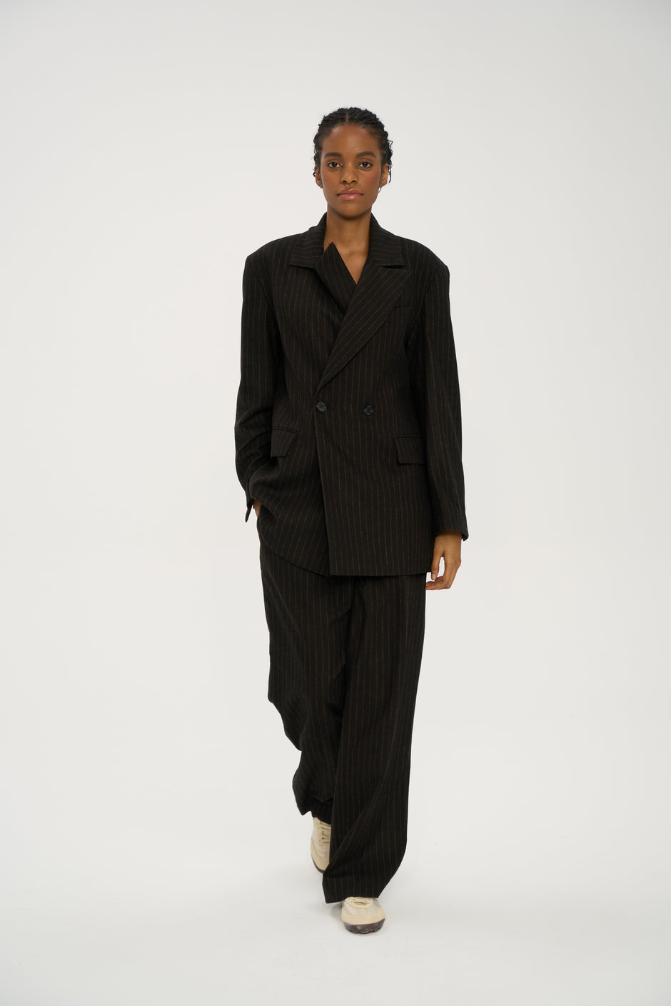Model wearing a black pinstripe suit on a white background - Inner Tiger