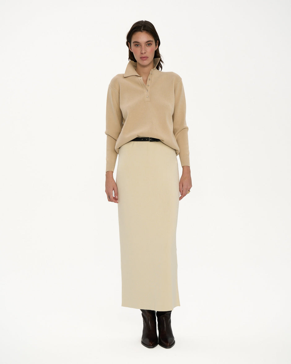 Woman wearing a beige sweater and skirt set on a white background